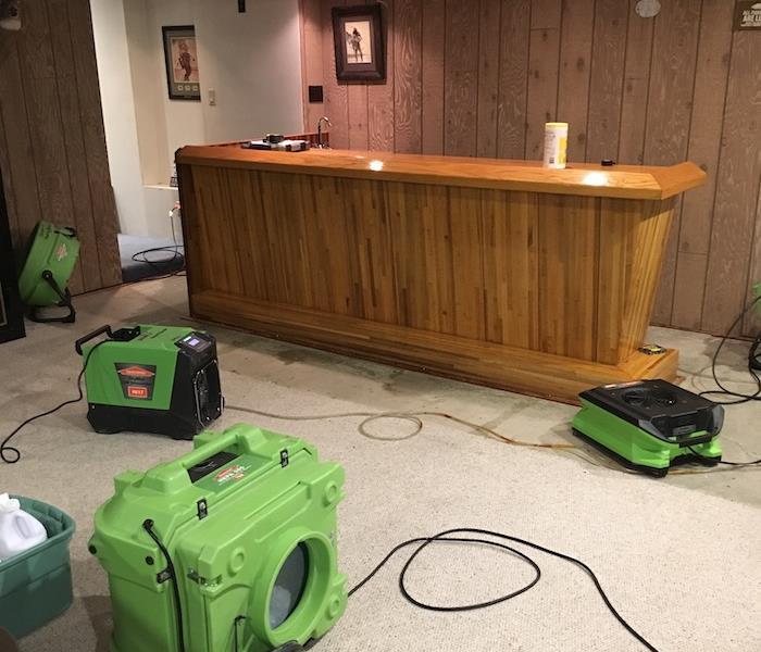 Airmovers drying a basement bar area with wood paneling