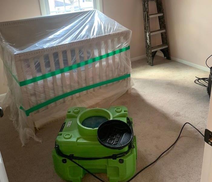  Room with plastic-covered crib and SERVPRO drying equipment