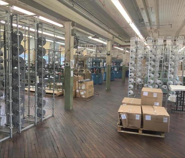 large interior warehouse, wooden floor, and spools of materials, fogged and cleaned